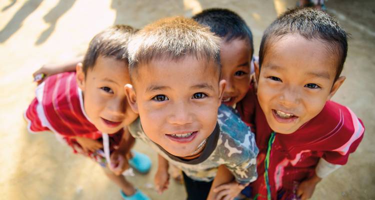 Four smiling children in a group photo.