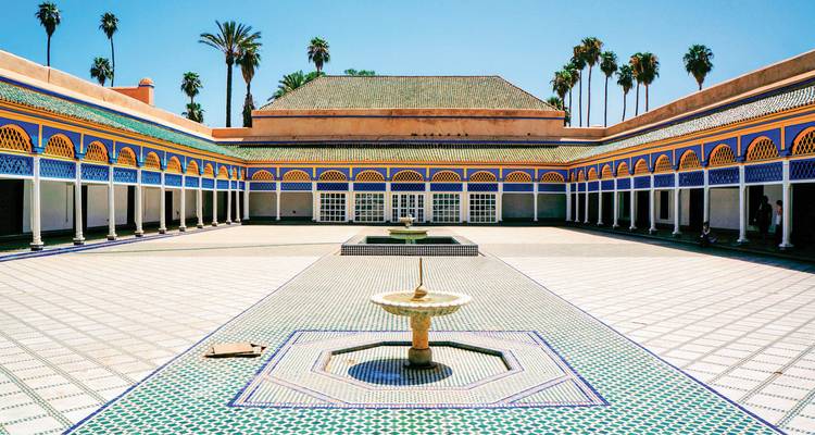 A courtyard with traditional tile patterns and surrounded by a colonnade.