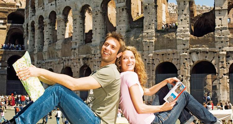 Un couple assis devant le Colisée à Rome, en Italie.