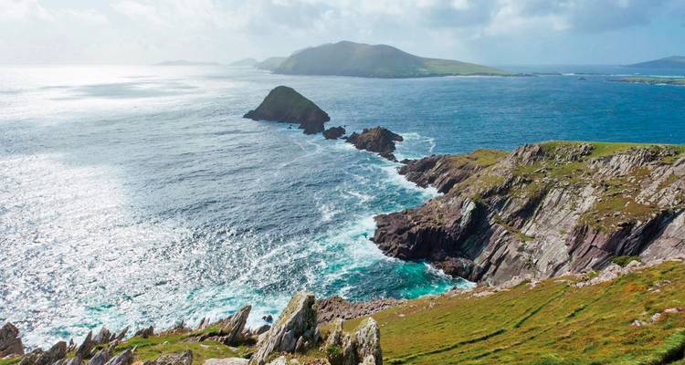 Scenic coastal cliffs with rocky outcrops extending into the sea.