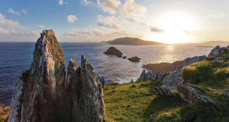 A sunset view of rugged coastline and islands.