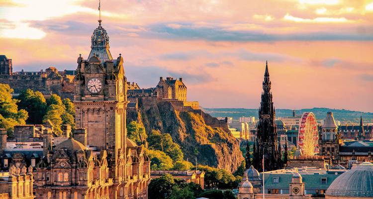 Un paisaje urbano de Edimburgo con edificios históricos incluyendo el Monumento a Scott y la torre del reloj al atardecer.