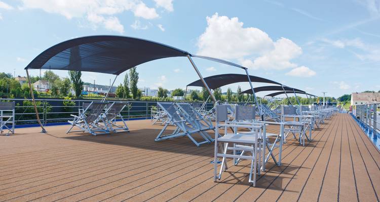 Zone de pont avec chaises longues et auvents sur un navire de croisière.