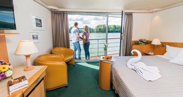 Pareja disfrutando de la vista desde una cabina de crucero fluvial.