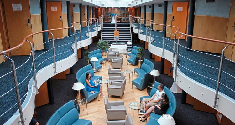 Une vue intérieure du salon d'un bateau de croisière avec des gens qui se détendent.