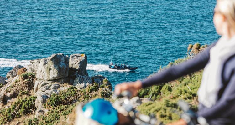 Vue floue d'un cycliste et d'un bateau sur un océan bleu.