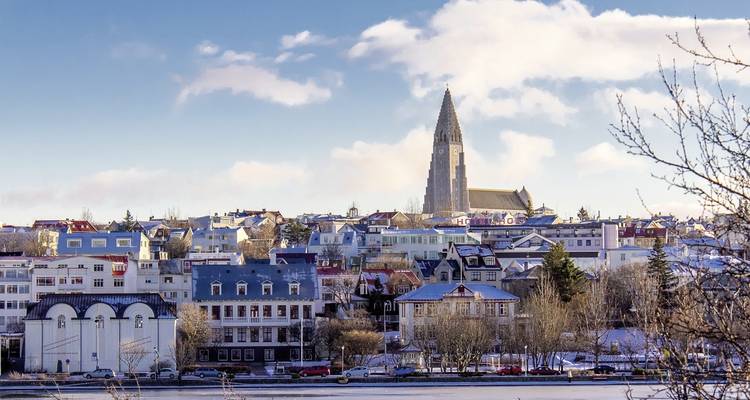 Casas cubiertas de nieve en una ciudad con una estructura de iglesia prominente.