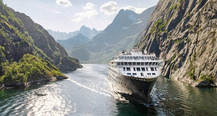 Un navire de croisière naviguant dans un fjord étroit ensoleillé.