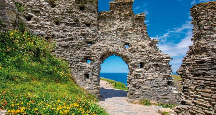 Ruines d'un château de pierre avec vue sur la mer.