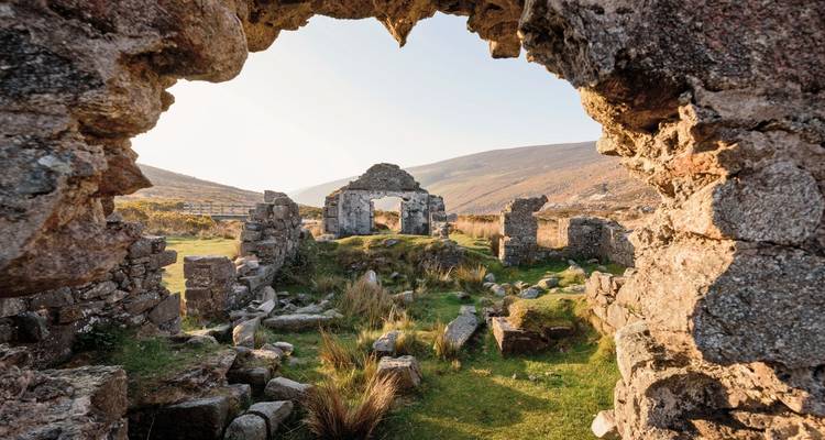 Ruines anciennes encadrées par une arche de pierre à Glendalough.