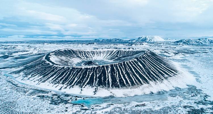 Aerial view of a volcanic crater covered in snow.