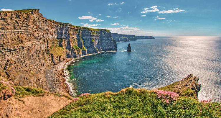 Majestic cliffs overlooking the sea with clear blue skies.