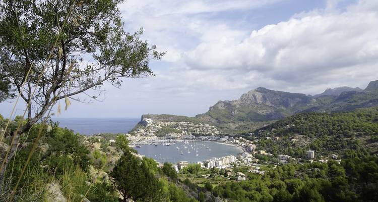 A coastal town with a bay and mountainous backdrop.
