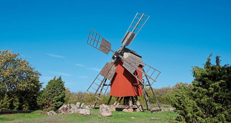 Traditional wooden windmill against a clear blue sky.
