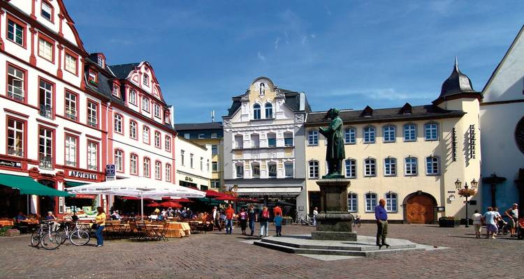Place de la ville entourée de bâtiments historiques.