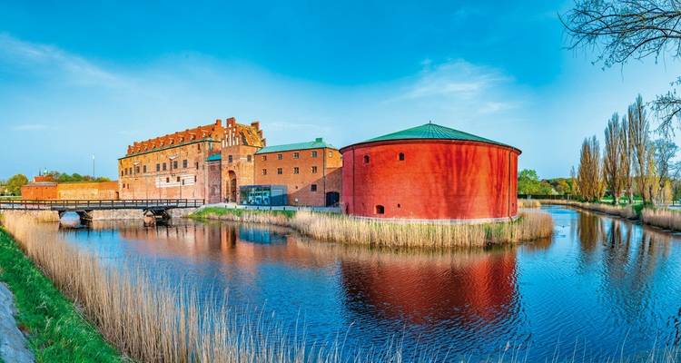 Historic red brick buildings with water reflections.