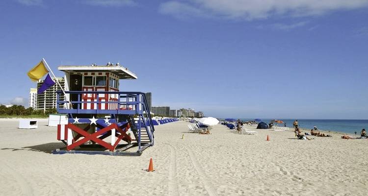 Beach scene with lifeguard tower and sandy shoreline.