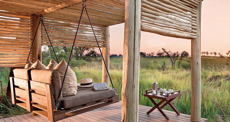 Élégants sièges extérieurs sur une terrasse en bois avec vue sur de vastes prairies.