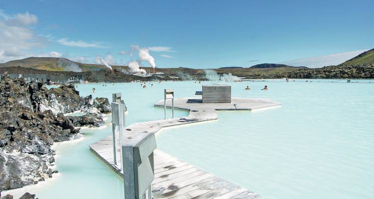 Lagon de source chaude avec des personnes se baignant dans une eau bleu laiteux.