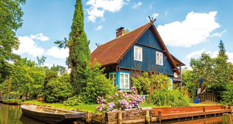 Charming house by a canal with lush greenery.