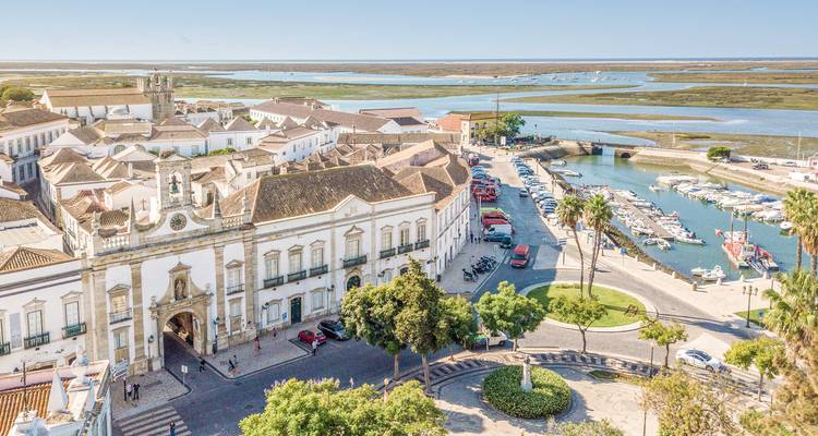 Vue aérienne d'un centre-ville historique avec une rivière et un parc.