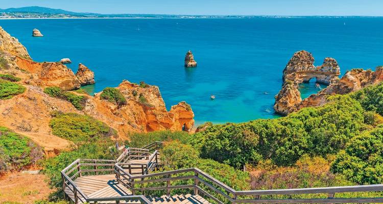 Paysage côtier avec des falaises oranges et une mer bleue limpide.