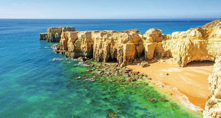 Vue magnifique sur des falaises dorées et l'eau turquoise de l'océan.