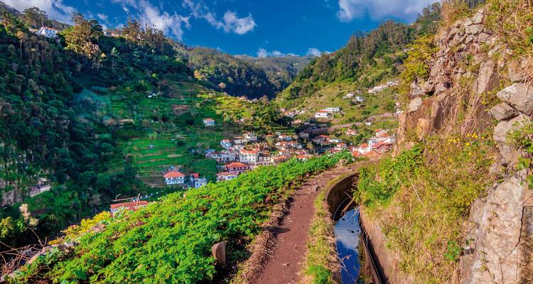 Vallée en terrasses avec un village niché dans des collines verdoyantes luxuriantes.