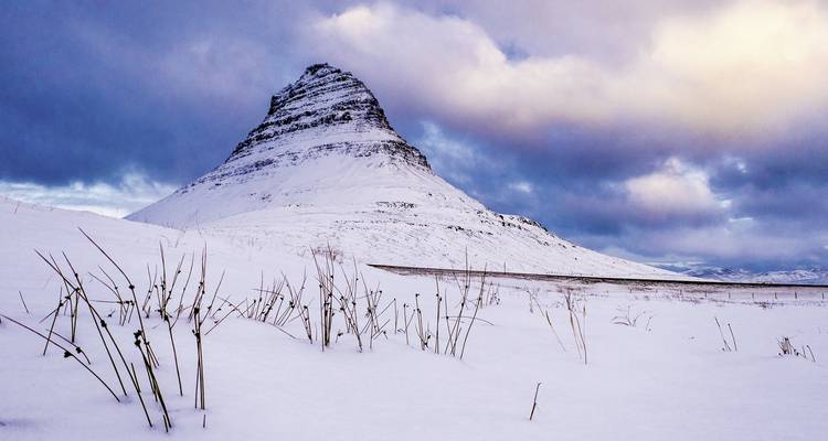 Schneebedeckter Berg unter bewölktem Himmel