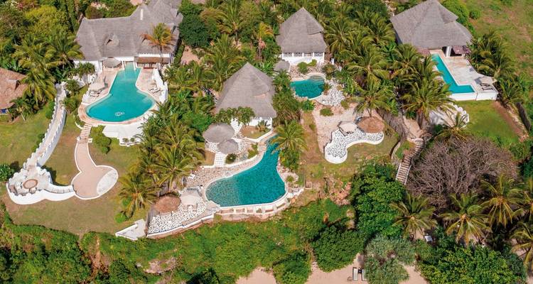 Resort aerial view with multiple pools and lush surroundings.