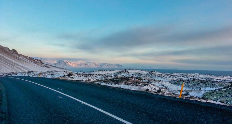 Snow-dusted road leading through an expansive winter landscape.