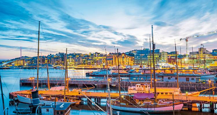 Un paysage urbain vibrant avec des bateaux amarrés dans le port au crépuscule.
