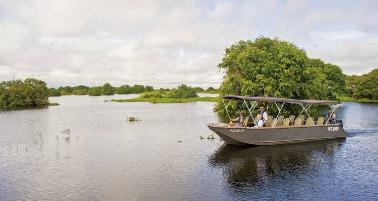 Toeristen op een boottocht door een waterweg met weelderig groen.