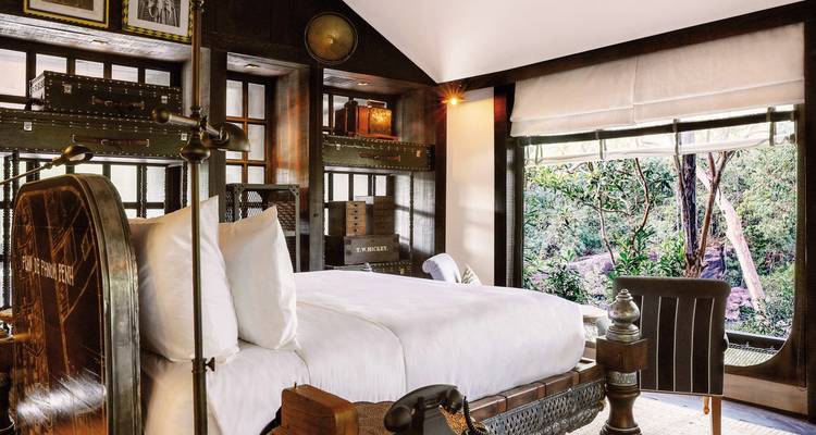 Luxueuze hotelkamer interieur met uitzicht op weelderig groen buiten.