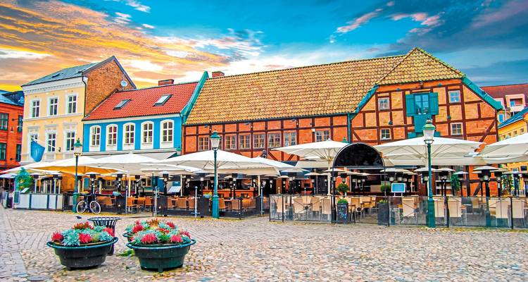 Place animée avec bâtiments historiques et terrasses extérieures.
