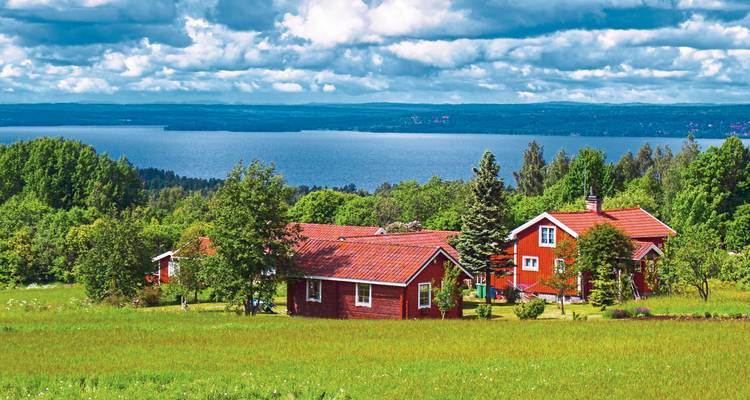 Maisons rouges avec vue sur un lac en arrière-plan.