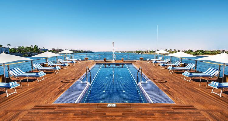 Sonnendeck auf einem Kreuzfahrtschiff mit Pool und Liegestühlen.