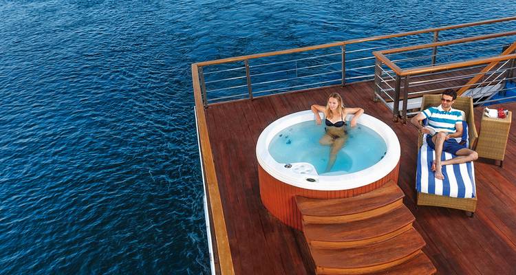 Menschen, die einen Whirlpool auf dem Deck eines Kreuzfahrtschiffs genießen.