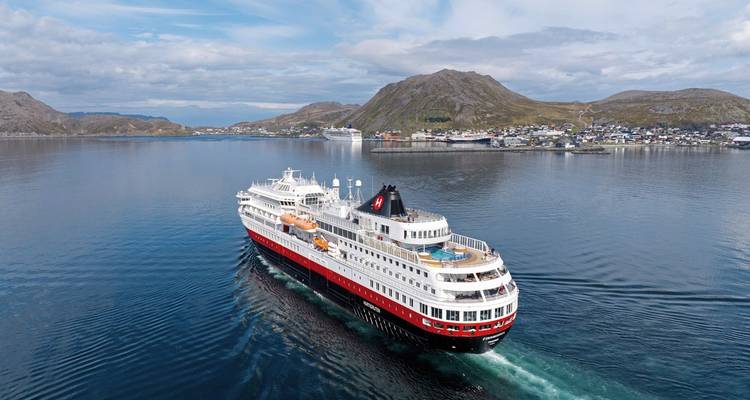 Crucero navegando a lo largo de un pueblo costero.