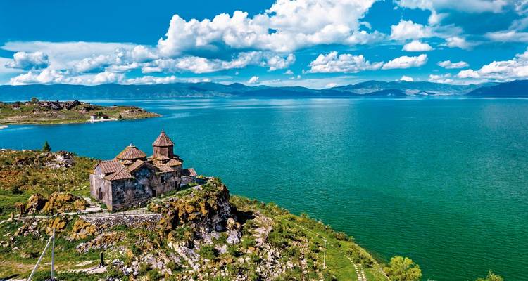 Klooster op een heuvel met uitzicht op een uitgestrekt meer.