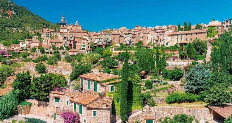 Vue panoramique d'un village pittoresque entouré de montagnes.