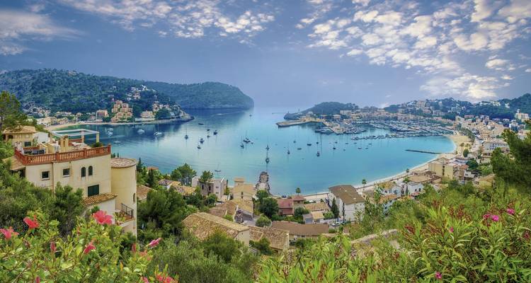 Une baie à couper le souffle avec des bateaux et des maisons sur les collines et un ciel dégagé.