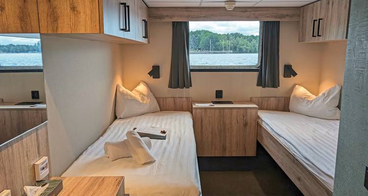 Chambre avec deux lits et vue sur l'eau.