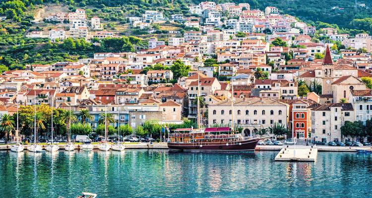 Ville côtière avec un port de plaisance et des yachts le long de bâtiments colorés.