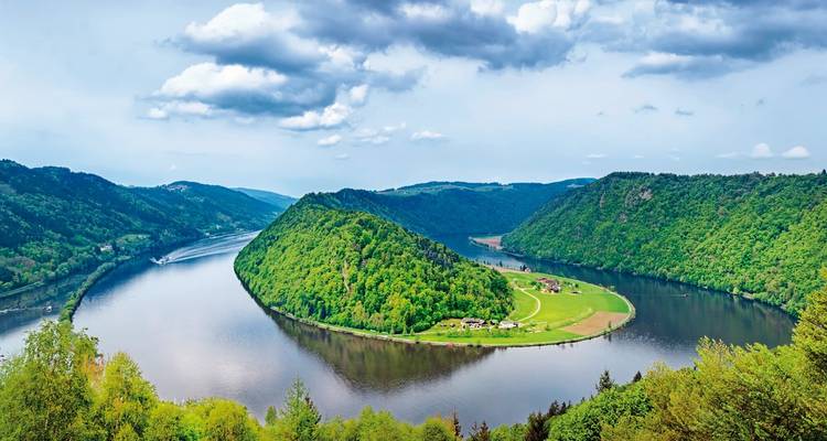 River bend with lush green hills and clear skies.