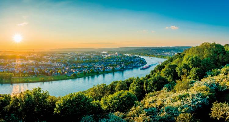 Malerischer Flussblick eingerahmt von Grün bei Sonnenuntergang
