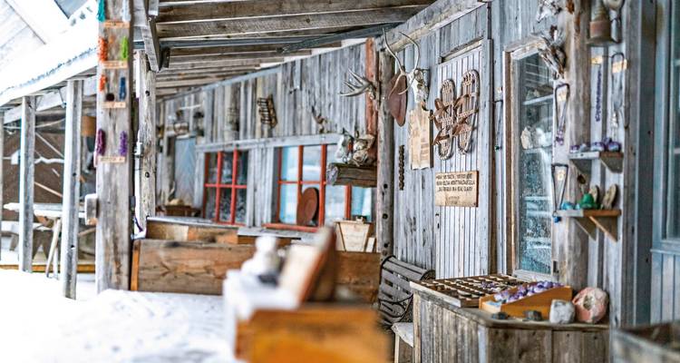 Close view of a rustic wooden building with snow covering the ground.