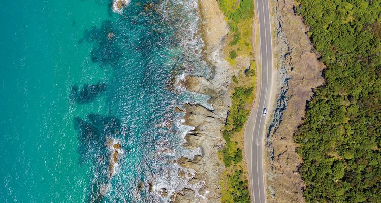 Aerial view of a coastal road alongside blue waters.