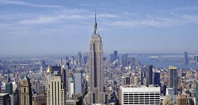 L'Empire State Building visible parmi d'autres gratte-ciel par temps ensoleillé.