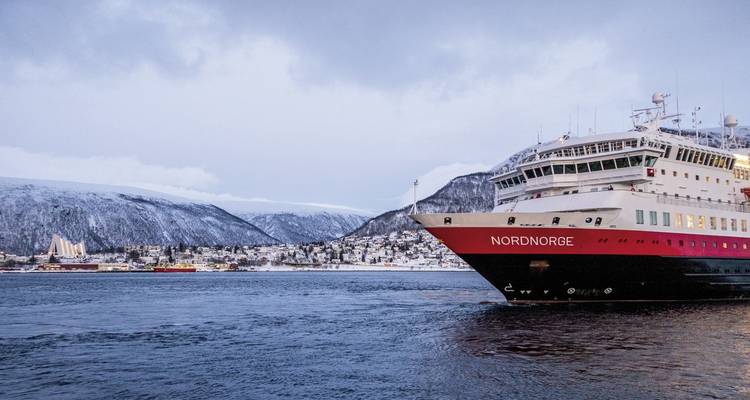 Navire de croisière près d'une ville côtière enneigée du nord de l'Europe.